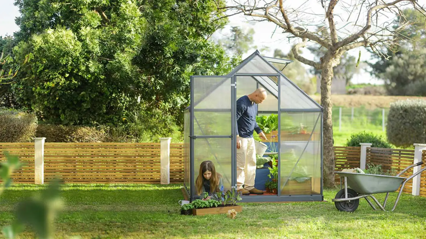 Canopia Greenhouse in a garden with a farther and dauther planting plants
